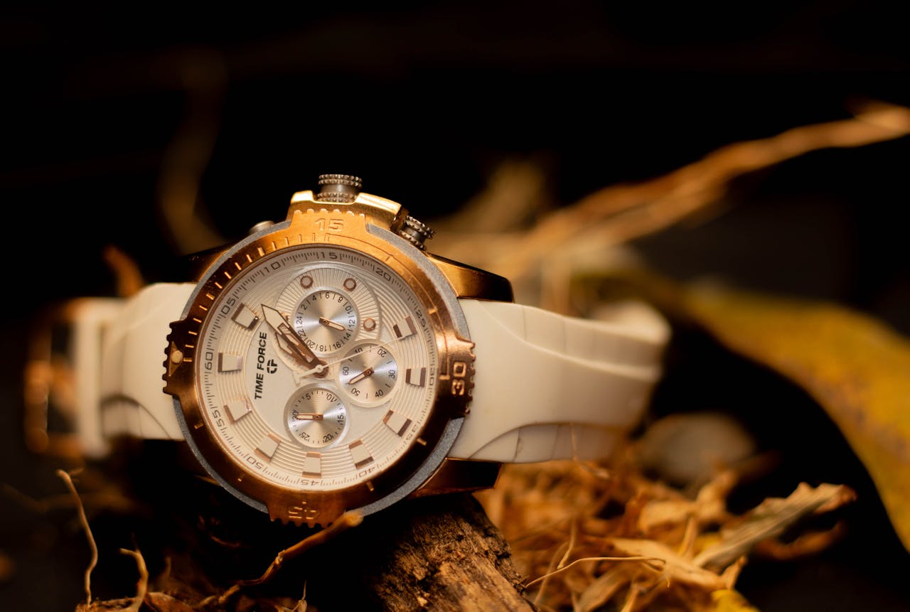 Detailed close-up of a stylish gold and white wristwatch on display with a rustic background.
